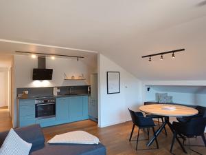a living room with a table and a kitchen at 2-Raum FeWo Alpenflair - Hallenbad & Sauna in Fischen +5 photos