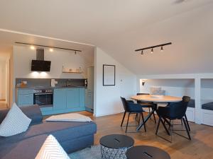 a living room with a blue couch and a table at 2-Raum FeWo Alpenflair - Hallenbad & Sauna in Fischen