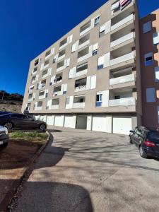 a parking lot in front of a large building at Apartman Tonka in Šibenik