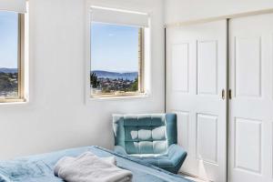 a bedroom with a blue chair and a window at Lizzy's Hideaway, Close to City in West Hobart +21 photos