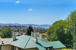 a house with a green roof and a city at Lizzy's Hideaway, Close to City in West Hobart