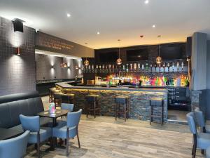 a bar in a restaurant with tables and chairs at The Queens Hotel in Cardenden
