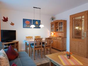 a living room with a table and a dining room at 2-Raum FeWo Alpenglück - Hallenbad & Sauna in Fischen