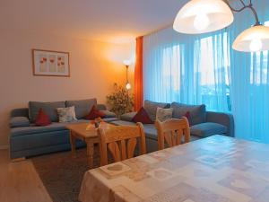 a living room with a couch and a table at 2-Raum FeWo Alpenglück - Hallenbad & Sauna in Fischen