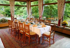 a long dining room with a table and chairs at Hotel Johannisbad in Bad Aibling