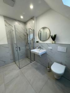 a bathroom with a shower and a toilet and a sink at Pension Romantica, Appartment Diana in Rust +29 photos