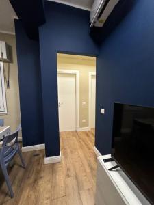 a living room with a blue wall and a television at Il Rifugio in Piazza in Castel di Sangro