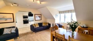 ein Wohnzimmer mit Tisch und ein Esszimmer in der Unterkunft 15 Penhale, Perranporth in Perranporth