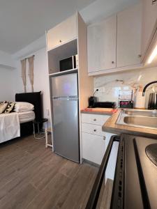 a small kitchen with a refrigerator and a bed at demis Mykonos stay 2 in Platis Gialos