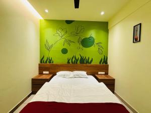 a bedroom with a bed with a green painting on the wall at Cous Cous Residency Hotel in Padinjarathara +18 photos