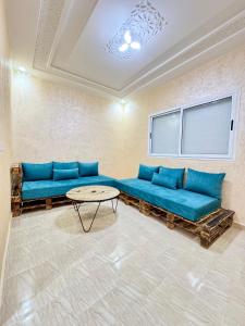 a living room with blue couches and a table at Menzeh saiss appartement in Fès