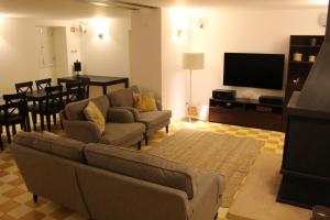 Una sala de estar con un sofá y un televisor de pantalla plana. en Tapada da Rabela - Reserva Natural, en Marvão
