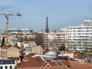 a view of a city with the eiffel tower at FAMILY APARTMENT's LUXURY in Montrouge