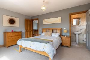 um quarto com uma cama grande e um lavatório em Kenmare HH em Kenmare