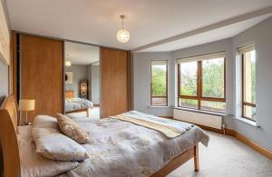 um quarto com uma cama grande e 2 janelas em Kenmare HH em Kenmare
