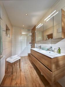 a bathroom with a sink and a large mirror at Ferienhaus zur Maultrommel in Molln +48 photos