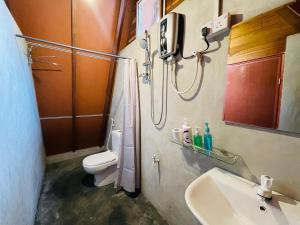 un bagno con doccia, lavandino e WC di Sigiriya River Side Villa a Sigiriya
