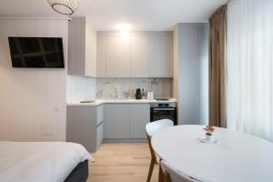 a white kitchen with a white table and a table and chairs at Springview Studio in Bucharest
