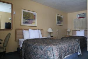 a hotel room with two beds and a window at Wakaw Lodge Motel in Wakaw