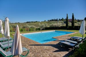 einen Pool mit 2 Liegestühlen und Sonnenschirmen in der Unterkunft I Glicini - Casa vacanze con piscina in Toscana a 30' da Firenze in Tavarnelle in Val di Pesa