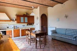 eine Küche mit einem Tisch und einer Couch in einem Zimmer in der Unterkunft I Glicini - Casa vacanze con piscina in Toscana a 30' da Firenze in Tavarnelle in Val di Pesa