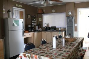 a kitchen with a table and a white refrigerator at Wakaw Lodge Motel in Wakaw