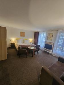 a hotel room with a bed and a table and chairs at Hotel MALEPARTUS am Kurpark in Bad Schwalbach
