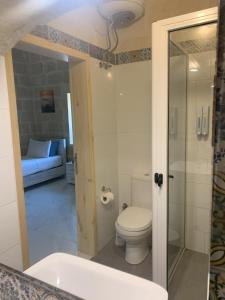 a bathroom with a toilet and a bath tub at Fiftyfour West Boutique Living in Għarb