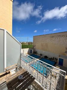 a balcony with a swimming pool on a building at Fiftyfour West Boutique Living in Għarb