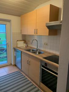 a kitchen with wooden cabinets and a sink at Ferienwohnung auf dem Land 2 in Wangerland