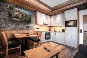 a kitchen with a wooden table and a dining room at AlpinSpa zur Post Apartment - Bergbahn im Sommer 2025 inklusive in Bad Gastein