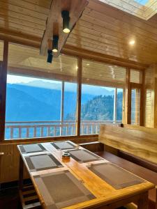 a room with a table and a view of a mountain at S Veer Homestay Sethan in Jagatsukh