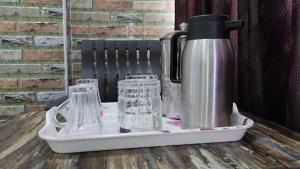 a tray with a thermos and glasses on a table at MERCY INN in Chennai