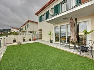 a backyard with a green lawn in front of a house at Ocean View Botânico in Funchal