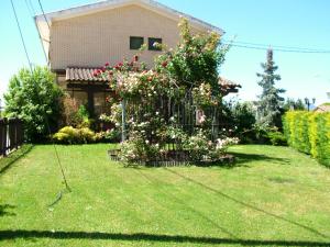 a yard with a fence with flowers and a house at Hostal El Botero in Cuzcurrita-Río Tirón