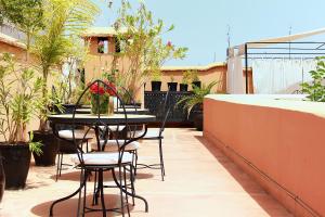 eine Terrasse mit einem Tisch und Stühlen auf dem Balkon in der Unterkunft Riad Davia in Marrakesch