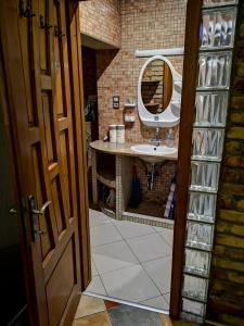 a bathroom with a sink and a mirror at Fortuna Vendégház Erkélyes Lakosztály in Kiskunhalas