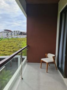 a white chair sitting on a balcony with a view at DKD ROOM Pererenan Canggu in Canggu