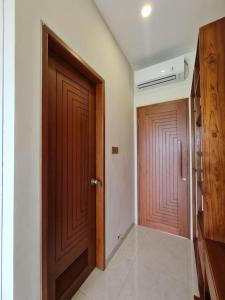 a room with a wooden door and a hallway at DKD ROOM Pererenan Canggu in Canggu