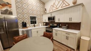 a kitchen with white cabinets and a table and a refrigerator at Valley View Resort Cabin 16, 1-Bed, Modern-Luxury with Hot Tub in Canaan Valley, WV in Davis