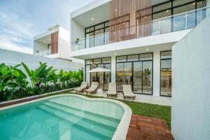 an external view of a house with a swimming pool at Villa Omnia Oasis Two Bedroom Garden Villa in Tumbak Bayuh