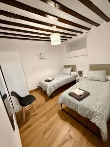 a room with two beds and a chair in it at Vivienda rural el gobernador in Villanueva de los Infantes