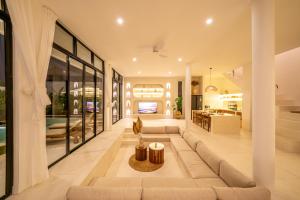 a living room with a large couch in a house at Villa Omnia Oasis Two Bedroom Garden Villa in Tumbak Bayuh