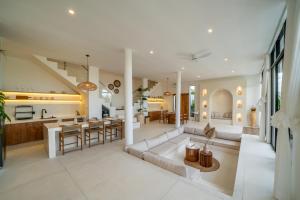 a living room and kitchen with a couch and a table at Villa Omnia Oasis Two Bedroom Garden Villa in Tumbak Bayuh