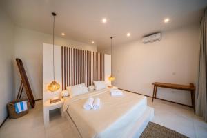 a bedroom with a large bed with two white towels at Villa Omnia Oasis Two Bedroom Garden Villa in Tumbak Bayuh +31 photos