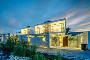 a large house with lights in front of it at Villa Omnia Oasis Two Bedroom Garden Villa in Tumbak Bayuh