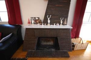 a living room with a brick fireplace with a mantle at Le Gite 5 mn de Luchon - Jardin garage et parking in Benque-Dessous-et-Dessus +31 photos