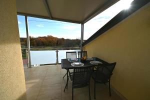 a balcony with a table and chairs and a large window at Silos Holiday in Dajla