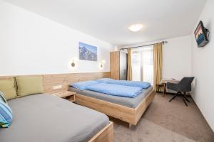 una camera da letto con due letti e una scrivania di Lippnerhof a Aschau