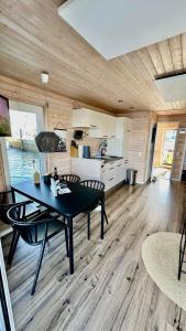 een kamer met een tafel en stoelen en een keuken bij Hausboot Koje INE Huus & Meer in Ortmühle